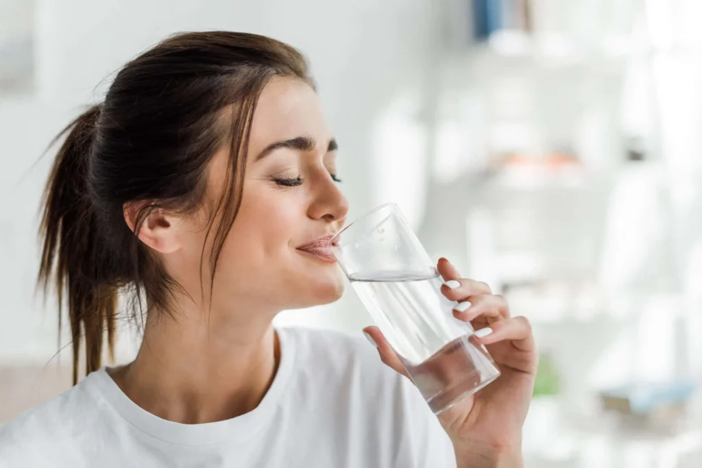 Strukturierung des Wassermoleküls mit iTeraCare. 4 mujer bebiendo agua saludable estructurada